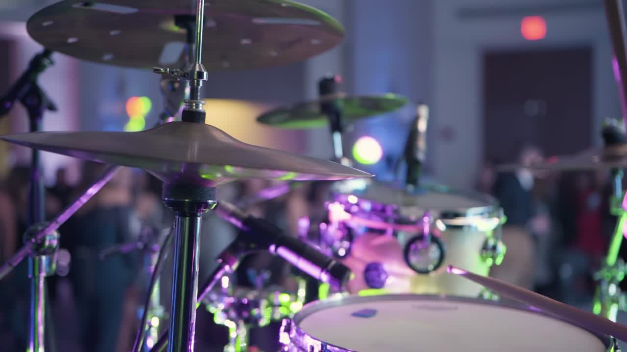 Batterista che suona un ritmo energico a un concerto dal vivo durante il ballo di fine anno, con la folla che balla