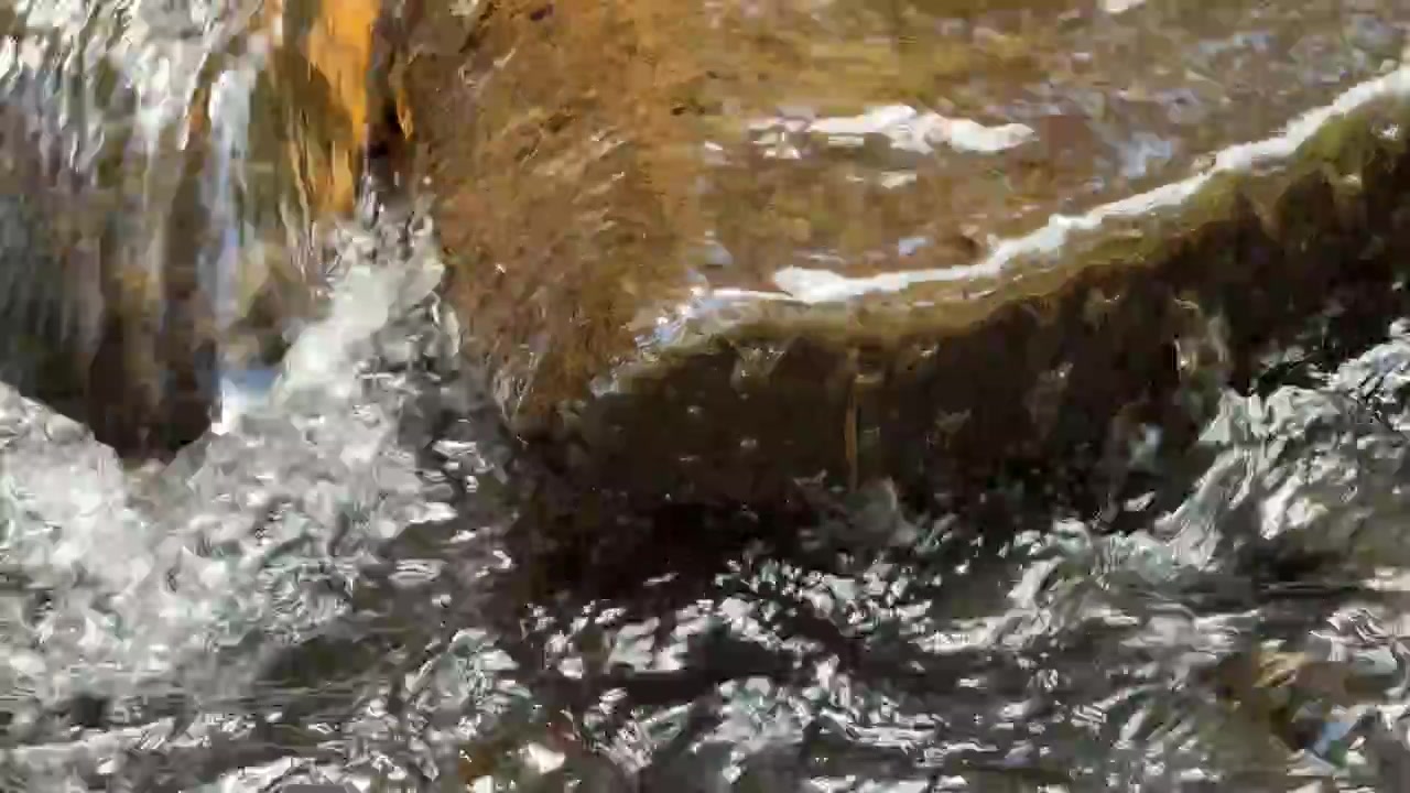Acqua cristallina che scorre su una roccia levigata di fiume