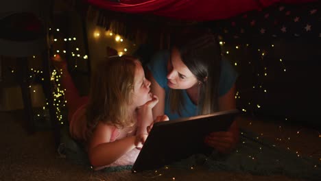 caucasian mother and daughter having fun using digital tablet