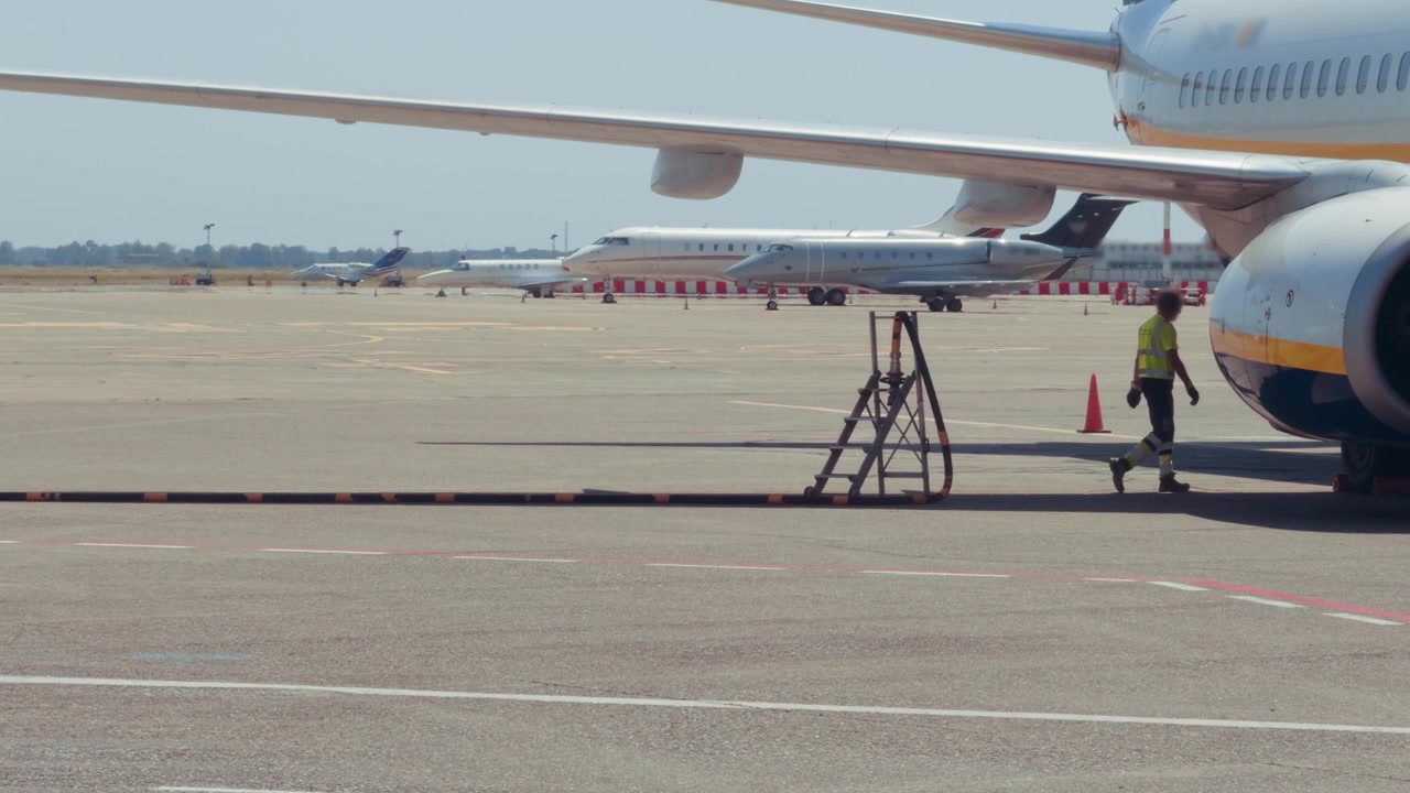 Personal de tierra junto a la aeronave durante el servicio de combustible para aviones