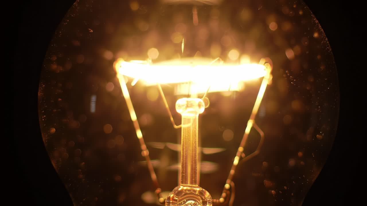 A glowing light bulb illuminates the surroundings with a warm, inviting glow. You can observe the intricate details of the filament and bulb structure, creating an elegant atmosphere.
