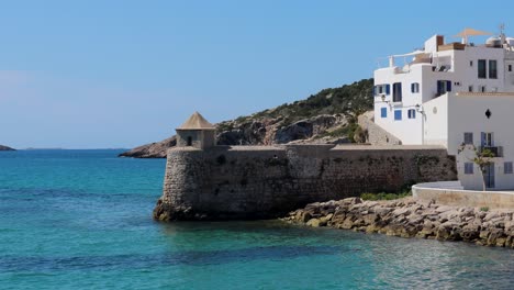 hermosa vista estática de una antigua torre con casas blancas cerca del paseo marítimo de ibiza, fondo mediterráneo de vacaciones
