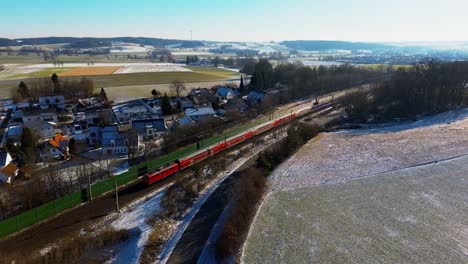 el tren de la mañana se desliza por un pueblo europeo cubierto de polvo de nieve.