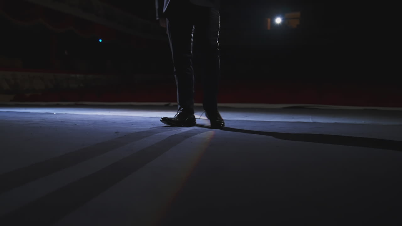 Actor dancing on stage. Man in stylish shoes and suit dances on a theater stage during the performance. Close-up.