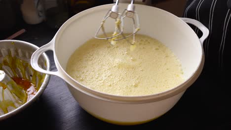 baker mixing homemade cake flan mixture with electric whisk