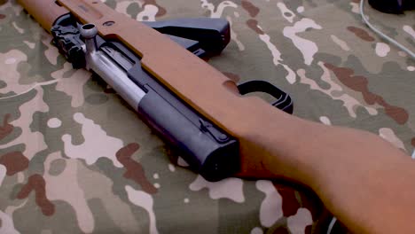 old soviet sks rifle displayed on camouflage fabric on table.