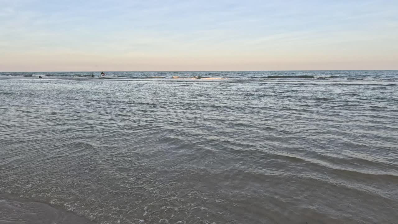 어두워지면 모래 해변을 는 부드러운 파도.