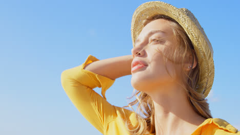 Front-view-of-young-Caucasian-woman-in-straw-hat-on-the-beach-4k