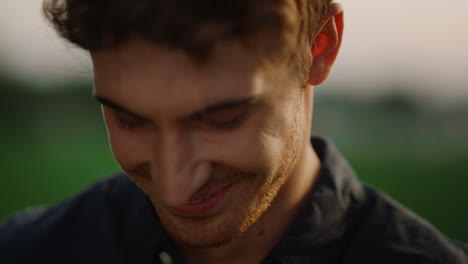 handsome man looking at camera outdoors at sunset