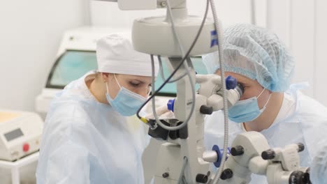 equipo de cirugía haciendo cirugía de estrabismo utilizando tecnologías modernas, dispositivos más recientes, microscopio en una clínica moderna