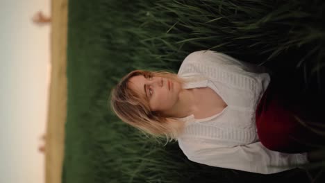 romantic woman in vintage apparel resting in field