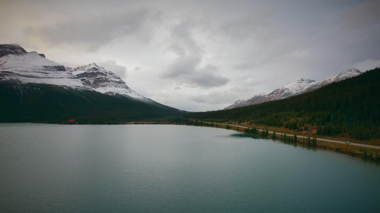 The stunning Banff mountains alongside a crystal clear blue water lake in Alberta, Canada.