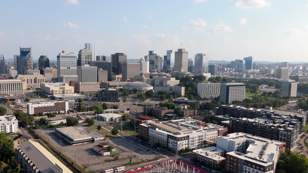 Downtown Nashville skyline, featuring Musicians Hall of Fame auditorium and state capital building in Tennessee's famous Music City, aerial forward approach