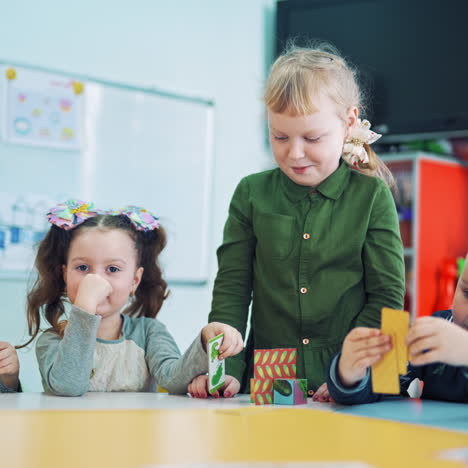 kleine jungen und mädchen lernen im klassenzimmer. eine gruppe kleiner kinder im unterricht in der schule. kleine kinder lernen, während sie am tisch mit bunten bildern spielen.