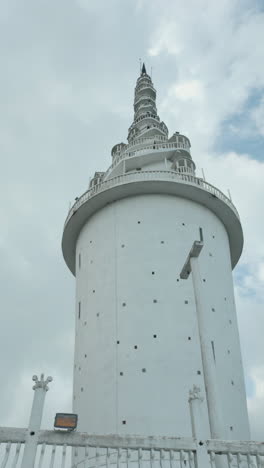 white round tower against a cloudy sky