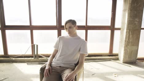 young trendy man sitting on chair in hall