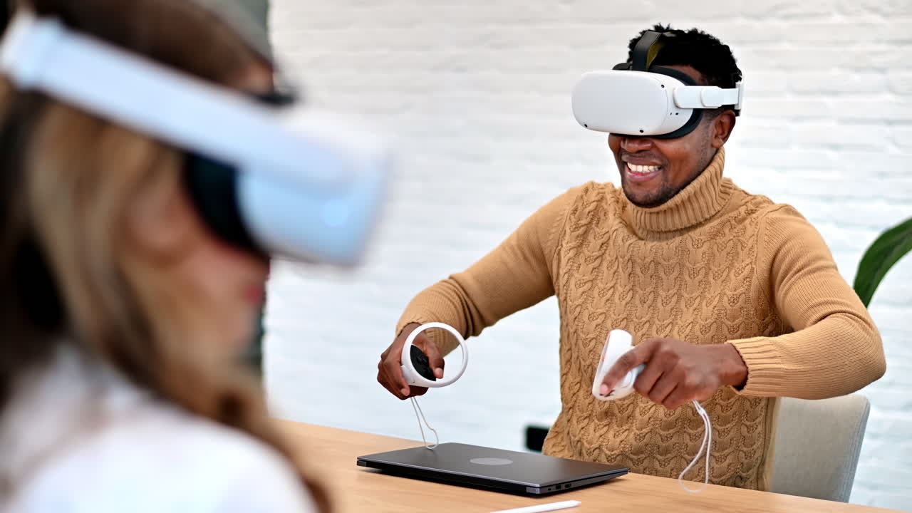Business conference in VR in an office. A black man and caucasian woman using VR glasses and controllers, gadgets on the table. Slow motion