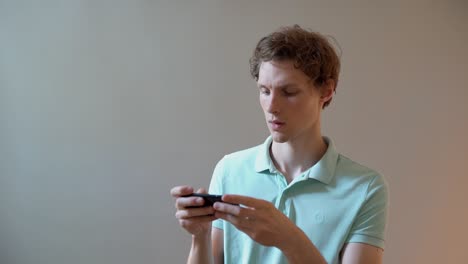 lindo joven escribiendo un mensaje en un teléfono inteligente