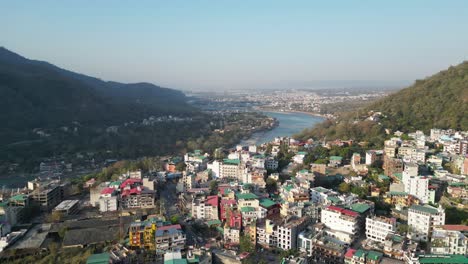 beautiful buildings on hills and ganga river going in rishikesh drone view in india