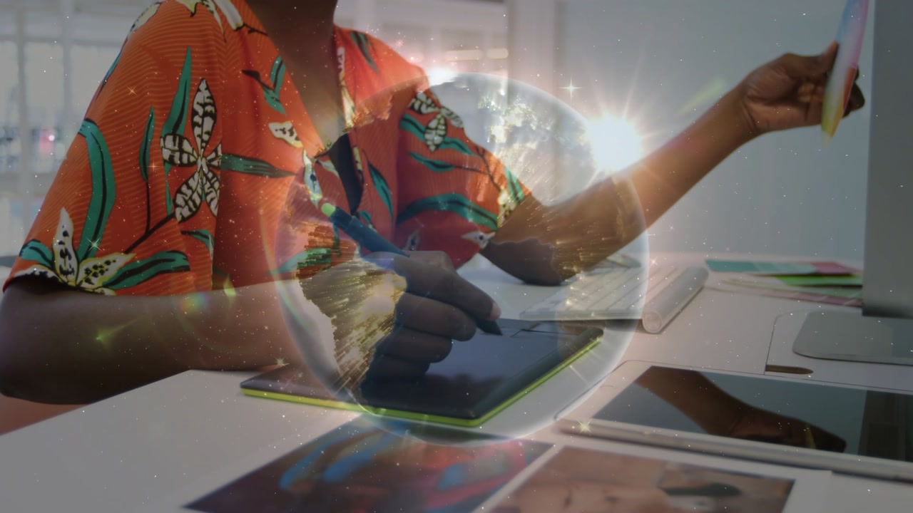 Graphic designer pressing stylus and drawing digital planet overlay while matching color swatch hue