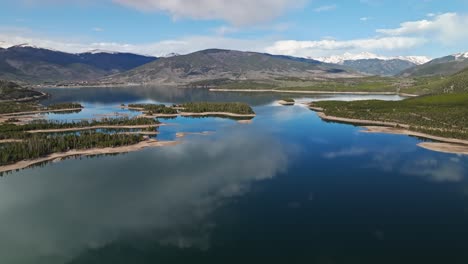 Aerial-pullback-above-evergreen-tree-stands-growing-in-sandy-banks-of-peaceful-waters-in-Frisco-Colorado