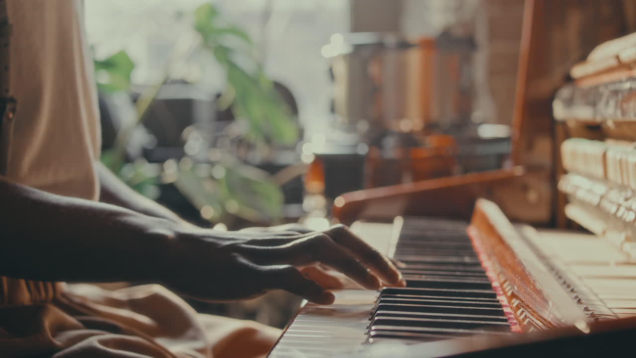 Person playing piano in a sunlit room