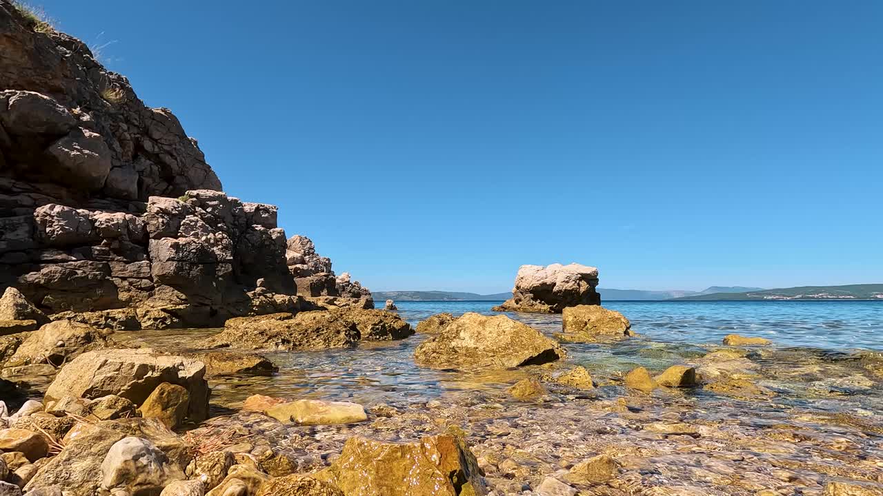 Naturist Woman Paddleboarding in Distance under Clear Blue Mediterranean Sky, Scenic Summer View of FKK Konobe Rocky Beach near Punat, Krk Island, Croatia Adriatic Sea, Coastal Cliffs, Islands