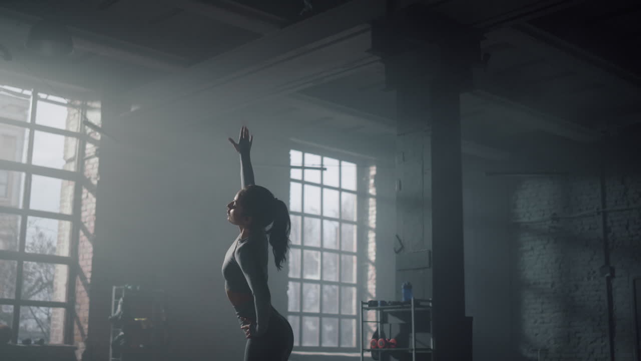 Woman preparing for workout in gym. Girl stretching body before training