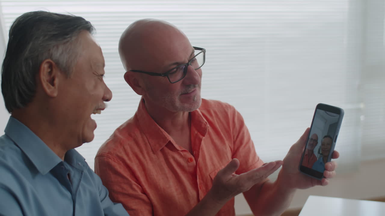 Senior Man Showing Friend How He Uses Camera on Smartphone
