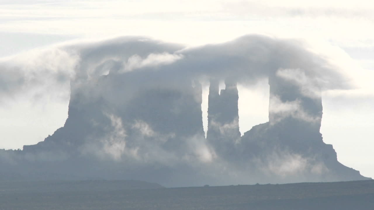 전경이 어두운 구름은 모뉴먼트 밸리 유타의 암석 위로 빠르게 움직입니다.