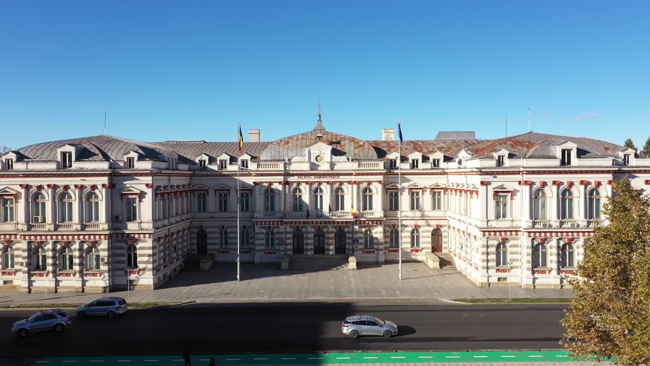 High-angle aerial shot of the majestic Palatul Administrativ in Bacau, Romania, home to the County Council. The historic architecture is bathed in bright sunlight on a clear autumn or early winter day