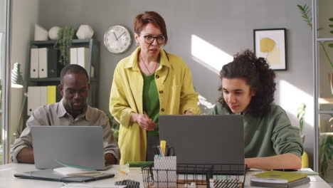 Mentora-De-Negocios-Femenina-Que-Trabaja-Con-Aprendices-Multiétnicos-En-El-Cargo