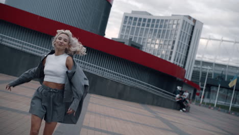 Running-girl-city-area-moving-near-modern-buildings-in-downtown-street.