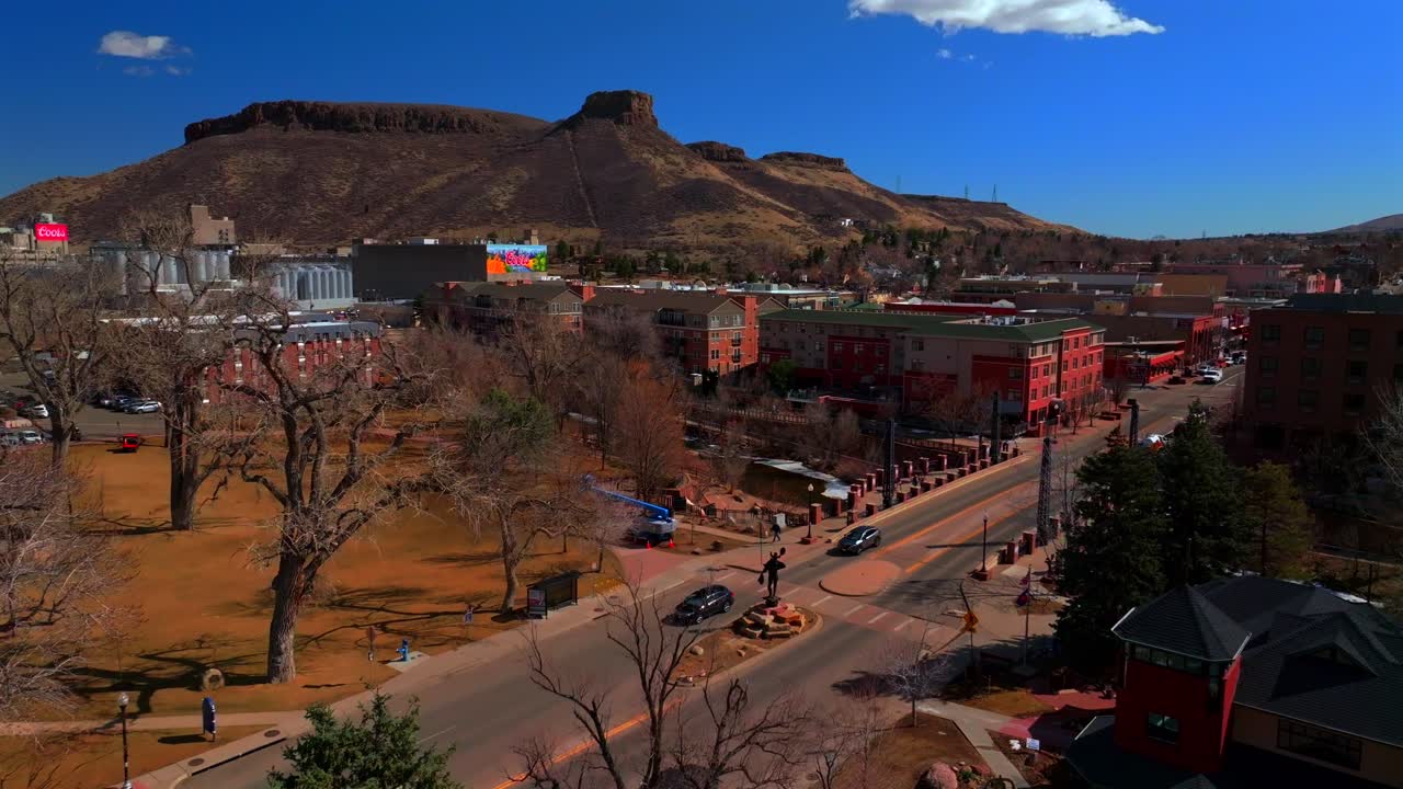 Historic downtown Golden Colorado aerial drone Clear Creek River North Table Mountain Coors Beer Factory Golden Gate Canyon winter sunny morning afternoon blue sky businesses buildings forward pan