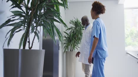 Diverse-female-and-male-doctors-standing-in-hospital-waiting-for-elevator