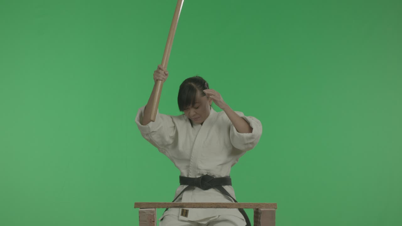 una joven deportiva está destrozando una manzana con un palo.