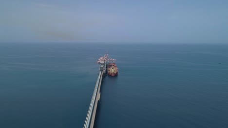 aerial footage of a large bulk carrier offloading coal for a large scale power plant