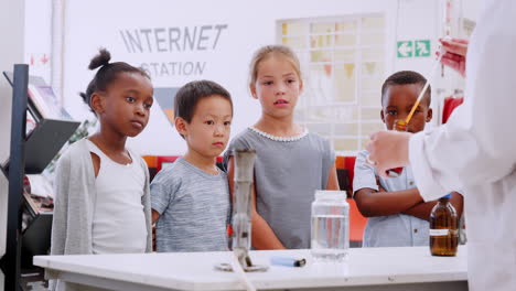 niños de la escuela viendo un experimento de química en el centro de ciencias.