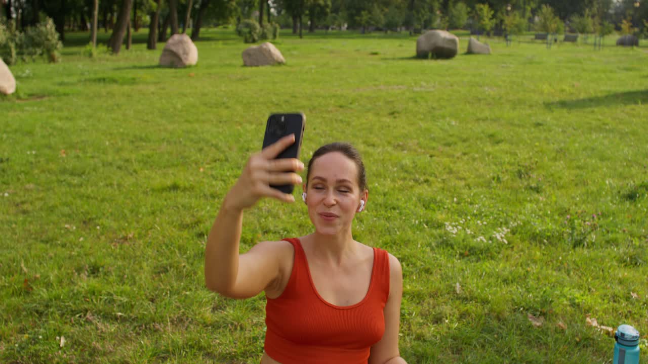 una mujer tomando una selfie en un parque.
