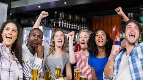 animation of gold confetti falling over happy diverse group of friends drinking in bar