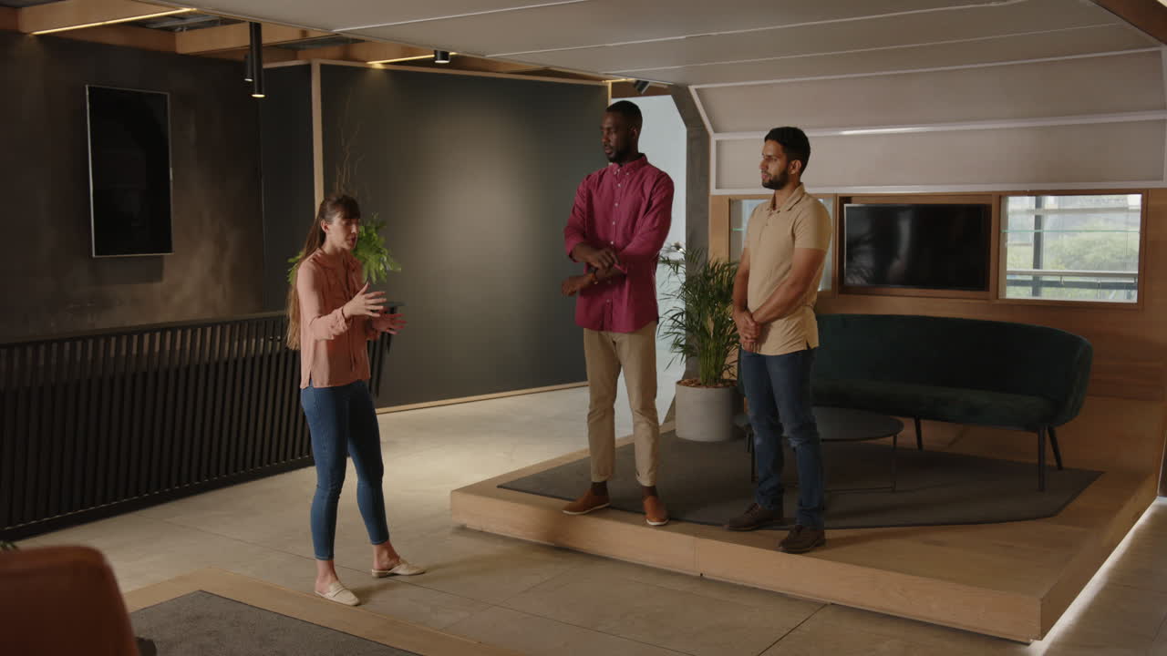 Presenting ideas, woman gesturing while two men listening attentively in office