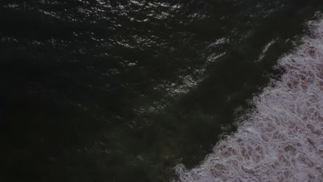 Clip-Aéreo-Vista-De-Pájaro-Que-Muestra-El-Mar-Y-Sus-Olas,-Al-Final-Hace-Una-Vista-Panorámica-Del-Horizonte