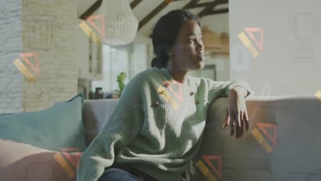 The-video-shows-a-thoughtful-african-american-woman-sitting-on-a-sofa-and-looking-outside-a-window