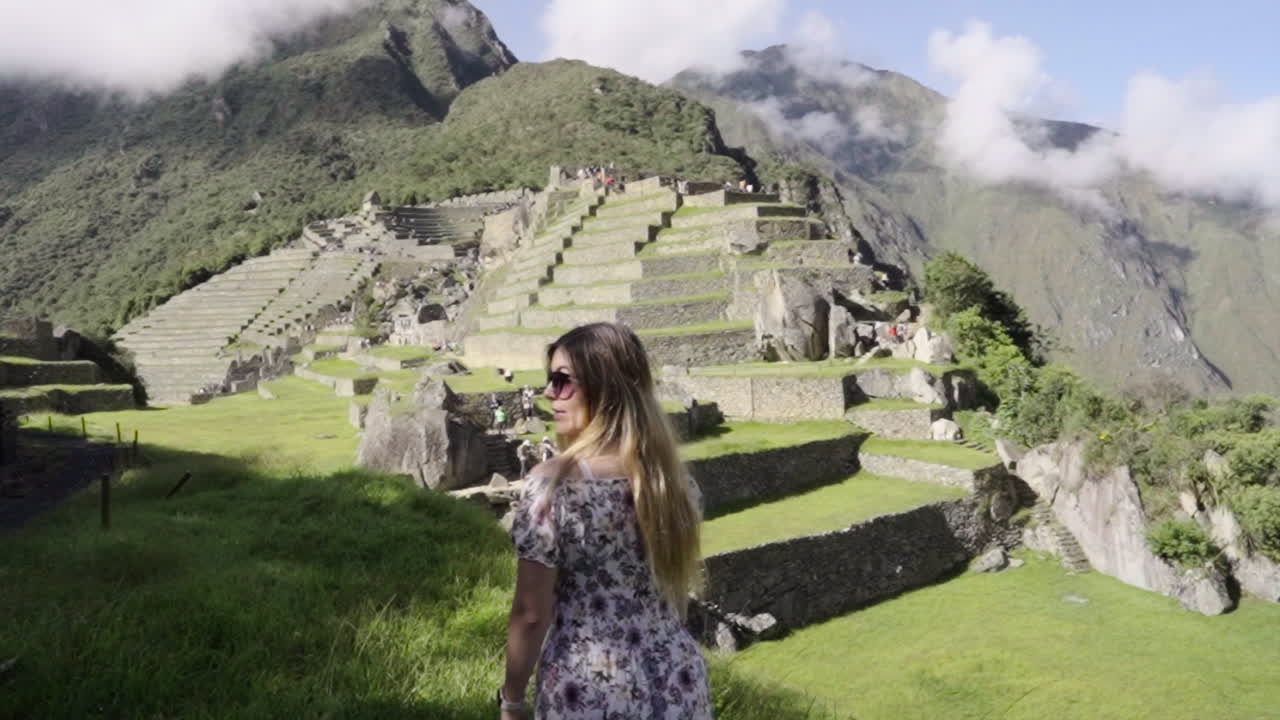 Tourist Woman Open her arms in front of Machu Picchu Lost City. Victorious happy wanderer traveler