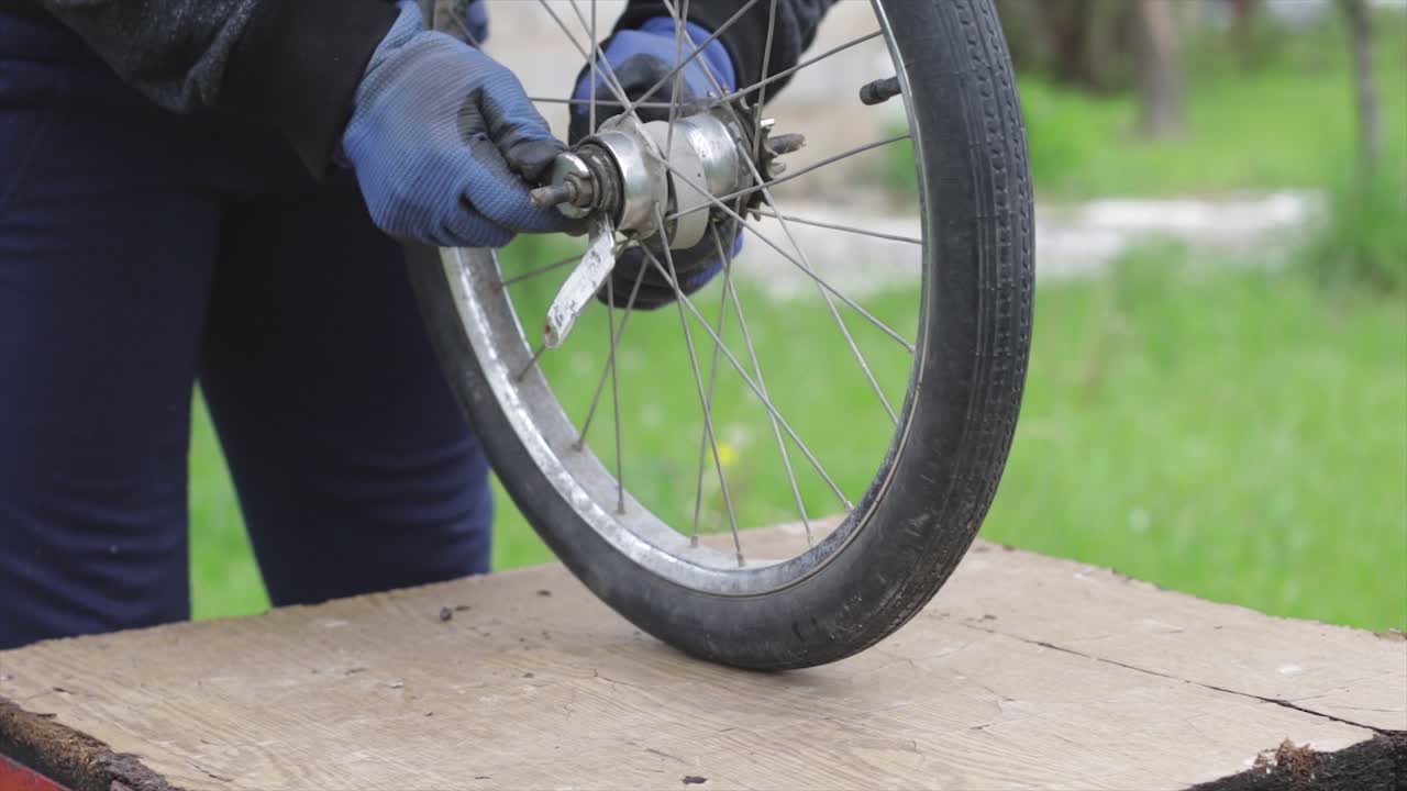 Mechanic repairing an old bicycle wheel. Worker fixing bicycle axis