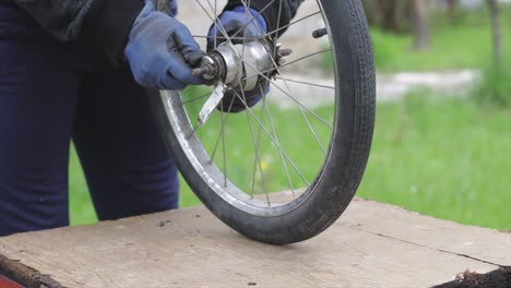 mechanic repairing an old bicycle wheel. worker fixing bicycle axis
