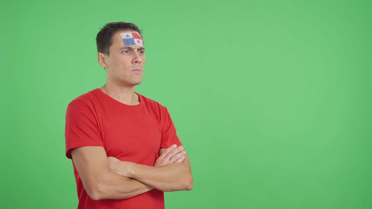 Man with panamanian flag painted looking away with serious expression