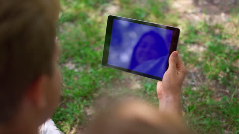 Unrecognized-man-use-tablet-outdoors-closeup.-Human-hand-holding-gadget.