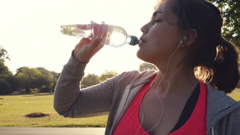 Fitness-woman-drinking-water-outdoors-in-park