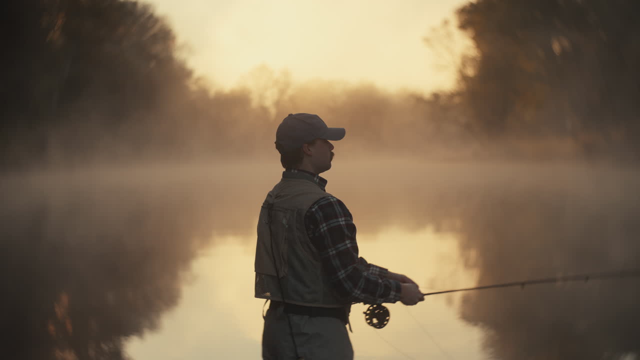 Fisherman Fly Fishing in a Misty Morning Sunrise